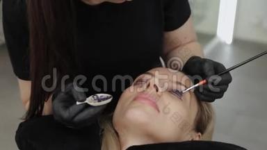 美容院的专业美容师给顾客画睫毛。